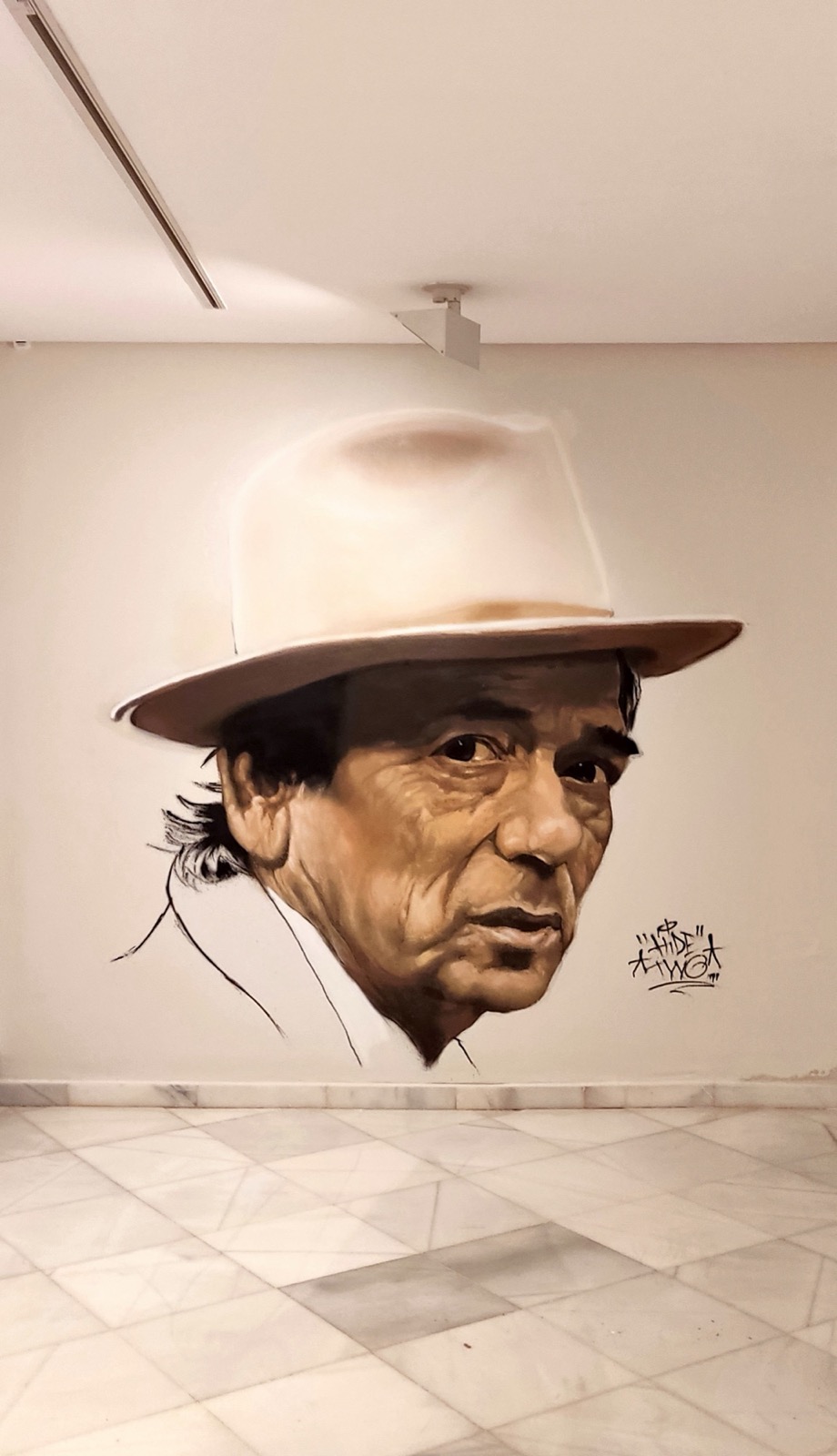 Retrato con sombrero pintado por Hidetwo en una pared interior